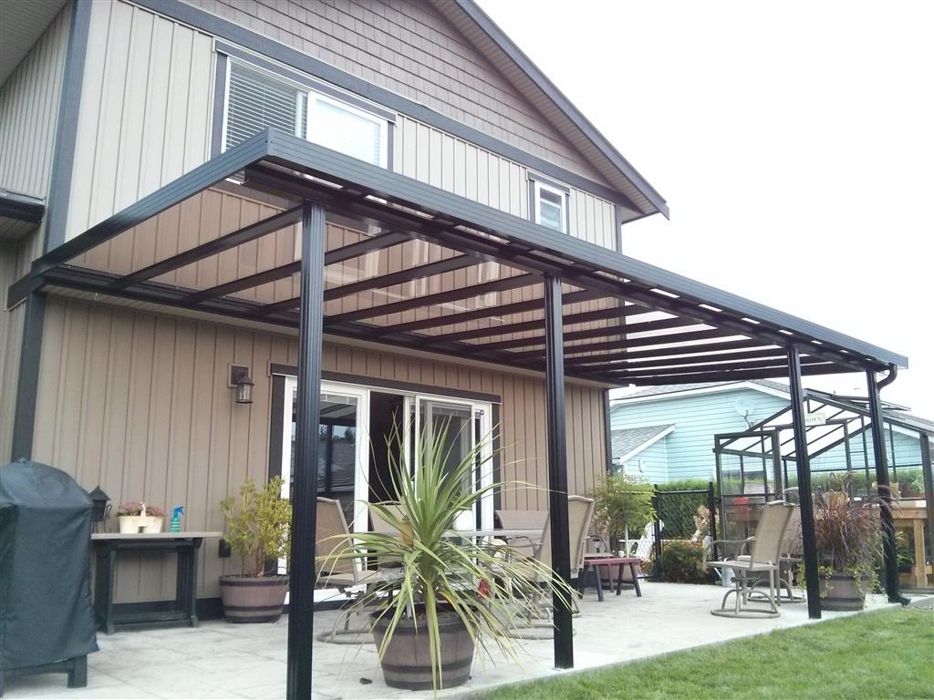 Glass patio cover with black trim and black posts.