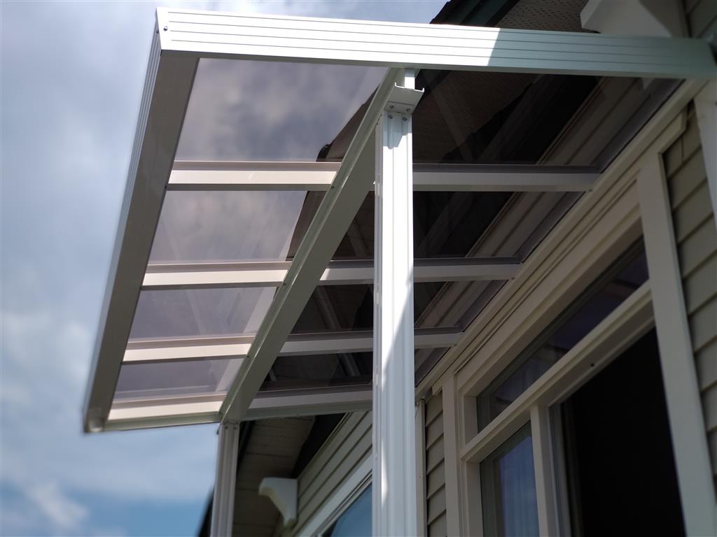 Glass patio cover with white trim and white posts.